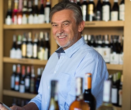 A wine shop owner among his shelves